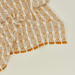 Close up view of Dove and Donkey hopsack napkin in honey