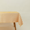 Dove and Donkey wicker fringed tablecloth in marigold on table