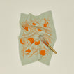 Clementine tea towel with brass handled whisk.
