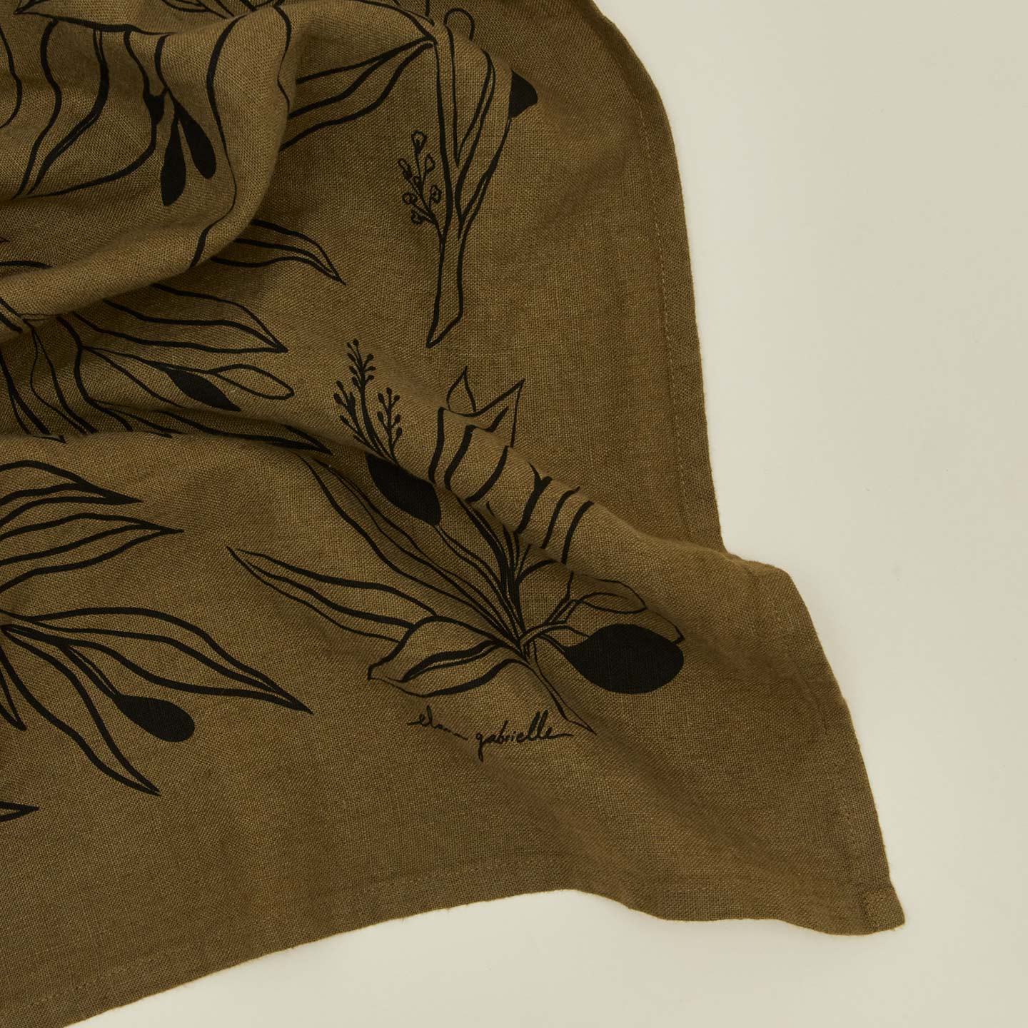 Close up view of linen tea towel with olives