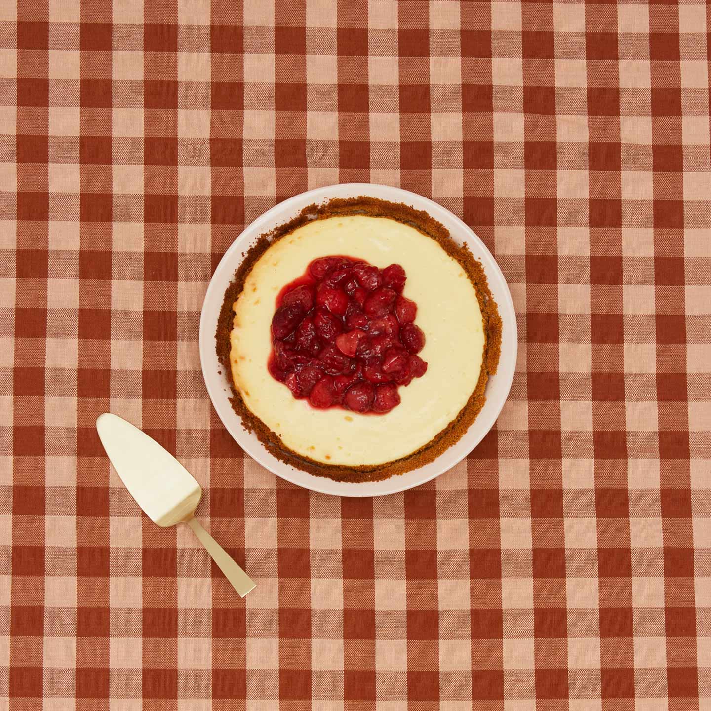 Essential pie dish with cheesecake with gingham background