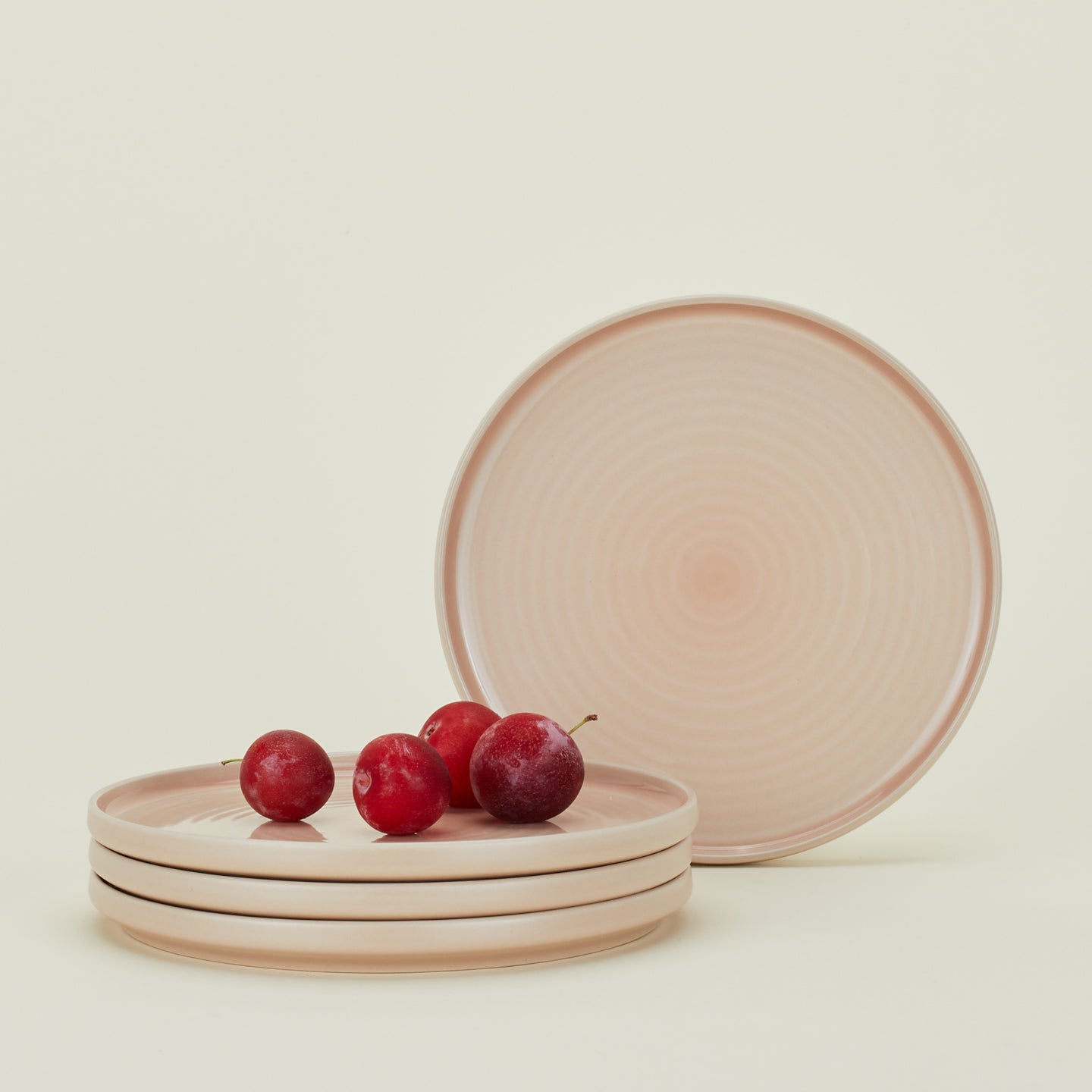 Four Essential Salad Plates in Blush, with plums.