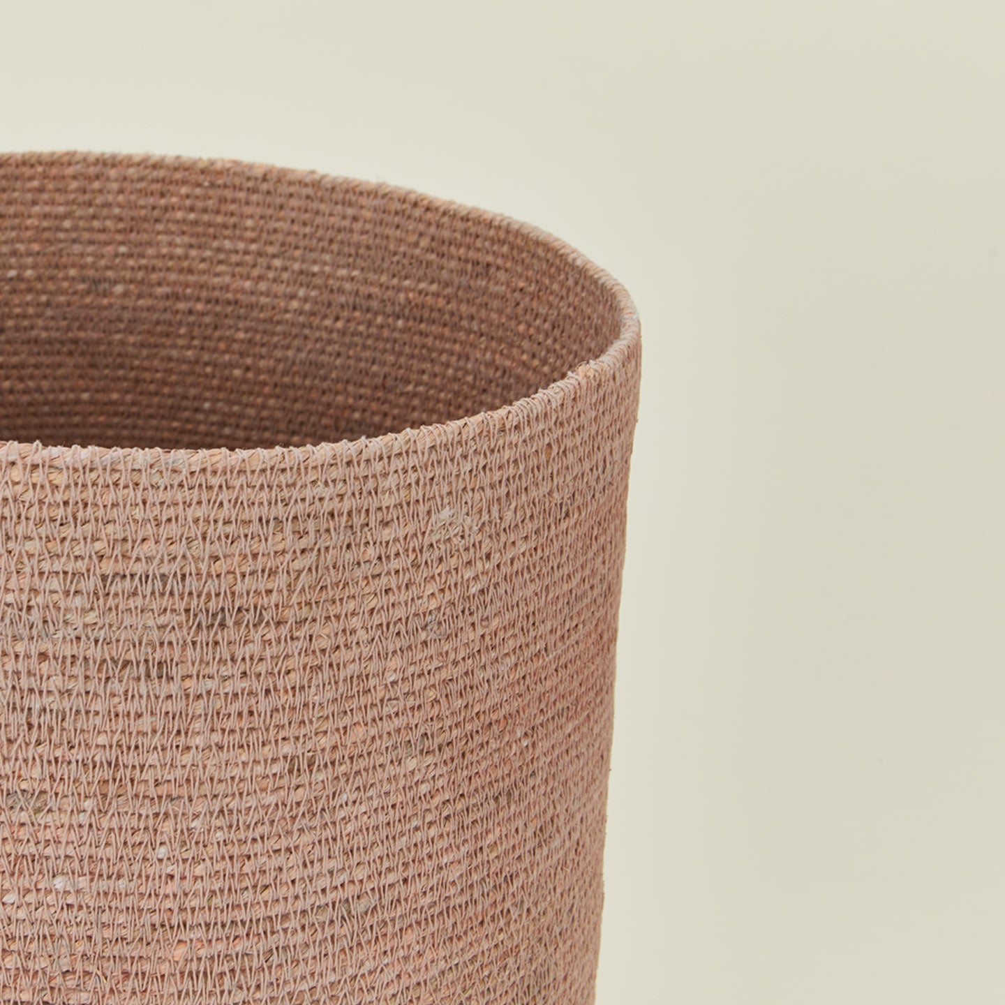 Close up view of essential woven wastebasket in blush