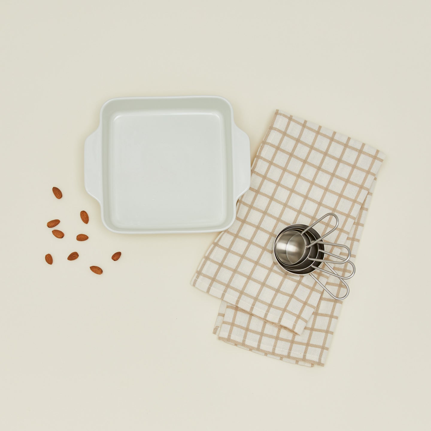 8" x 8" essential bakeware in bone with measuring cups, almonds, and dish towel