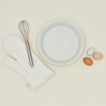 Essential pie dish in bone with whisk, eggs, and oven mit