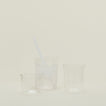Group of three Essential Glasses in Clear in various sizes, filled with water and fruit with a coordinating glass straw.