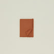 Folded Essential cotton tablecloth in terracotta.