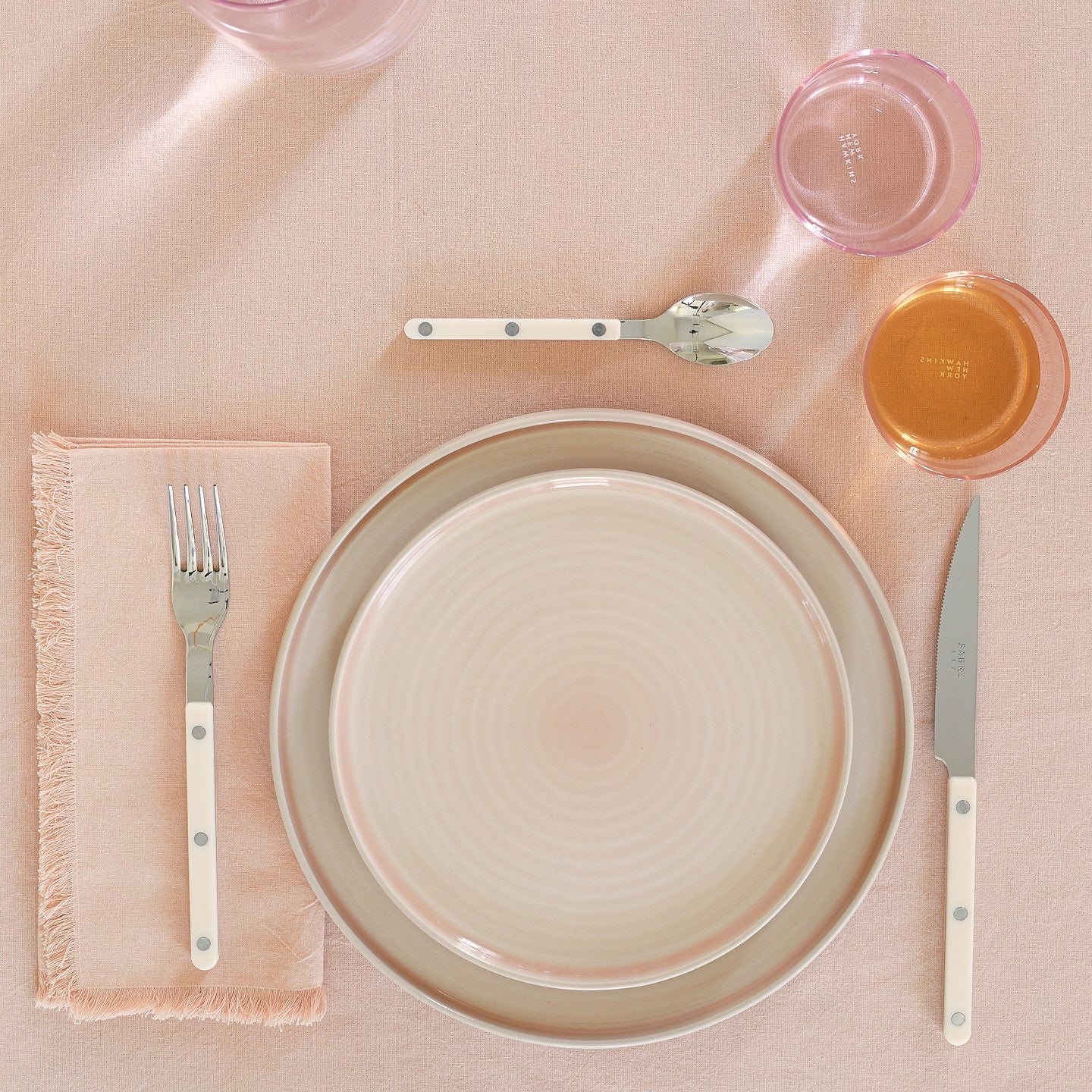 Placesetting with Essential Salad Plate in Blush on pink tablecloth.