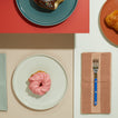 Essential Plates with donuts and Essential Striped Blush Dinner Napkin with blue fork.