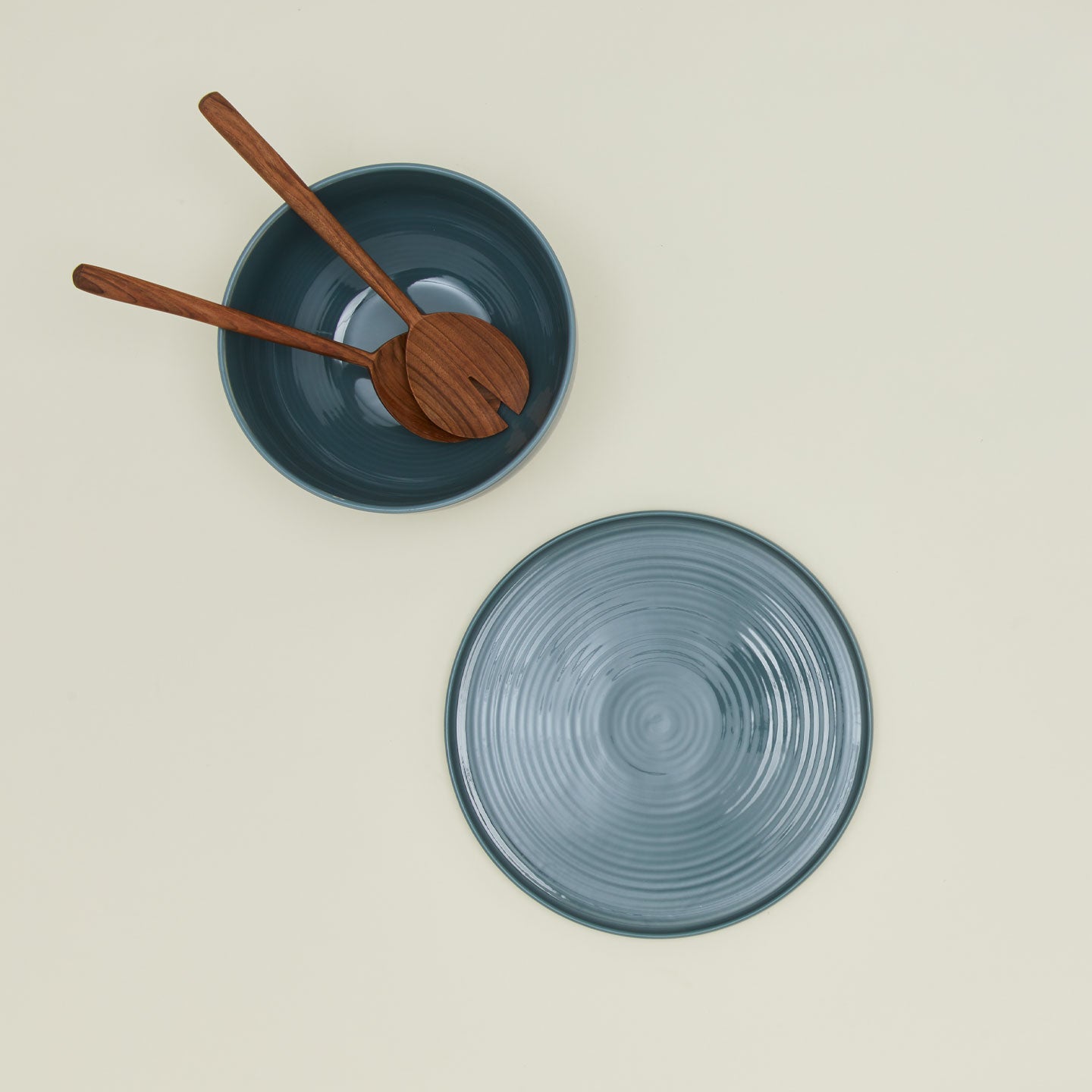 Overhead view of essential serveware set in peacock with wooden utensils