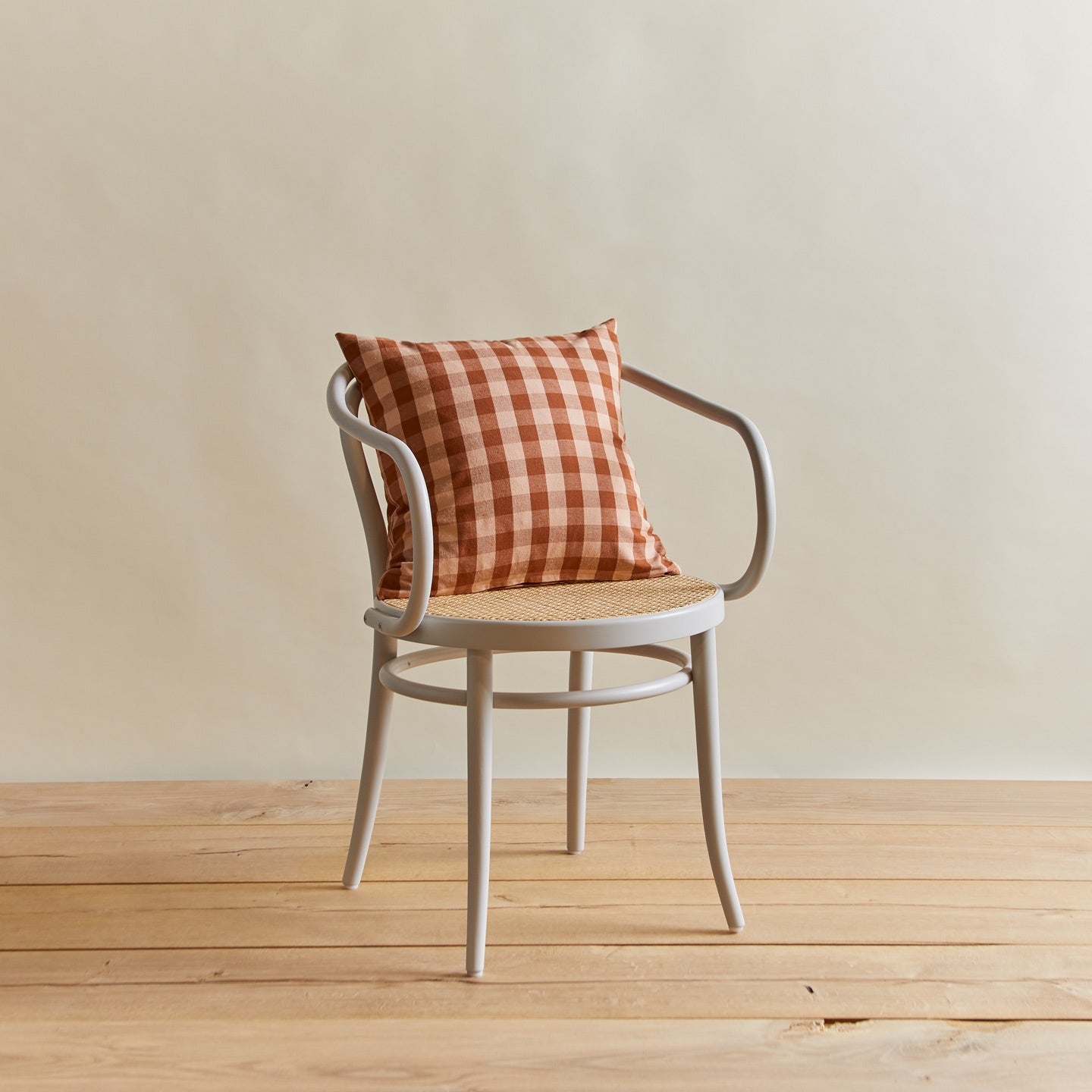 Essential gingham pillow in blush/terracotta on chair