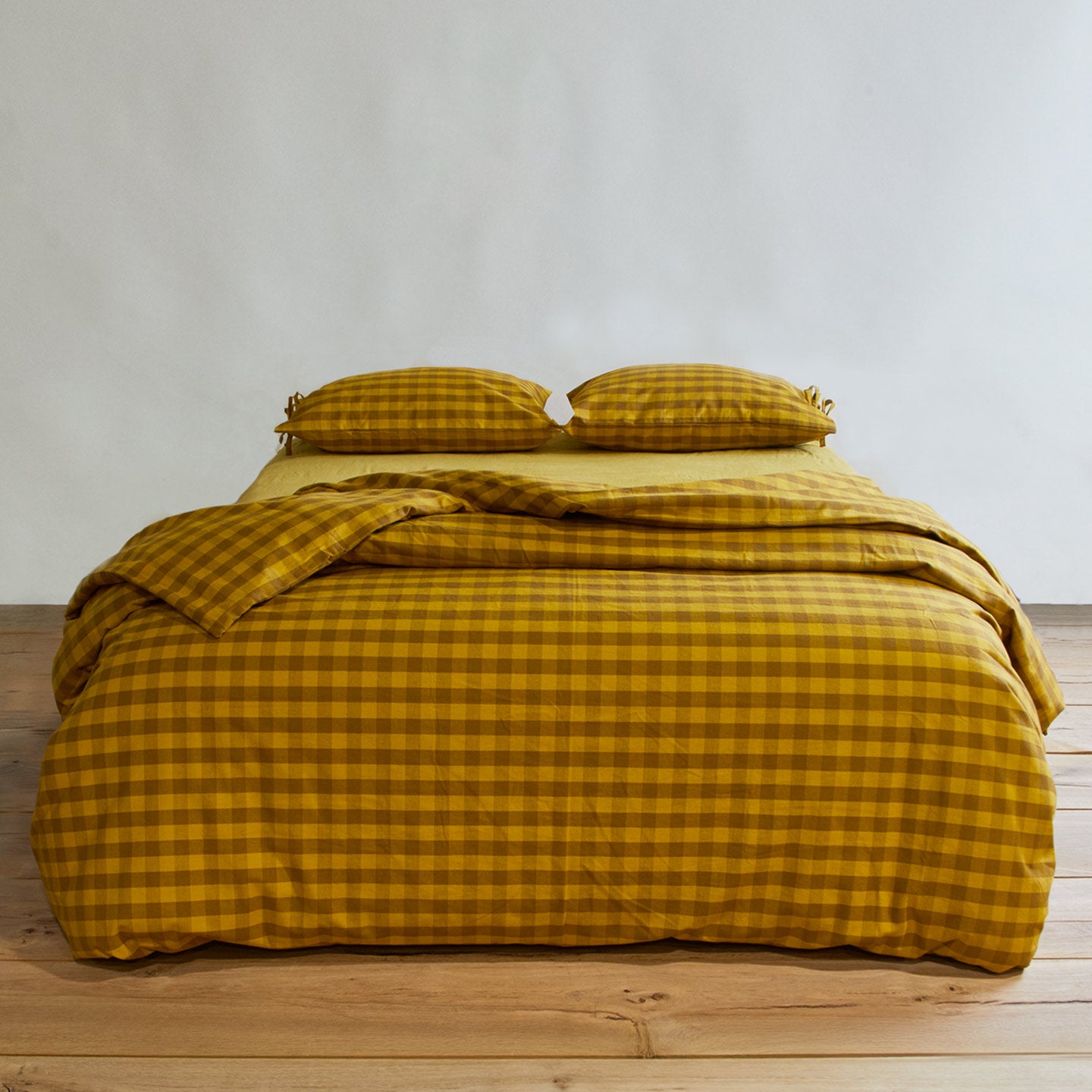 Essential Gingham Pillowcases, Set of 2 - Mustard/Bronze on bed with matching duvet