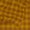 Close up view of Essential Gingham tablecloth in mustard/bronze
