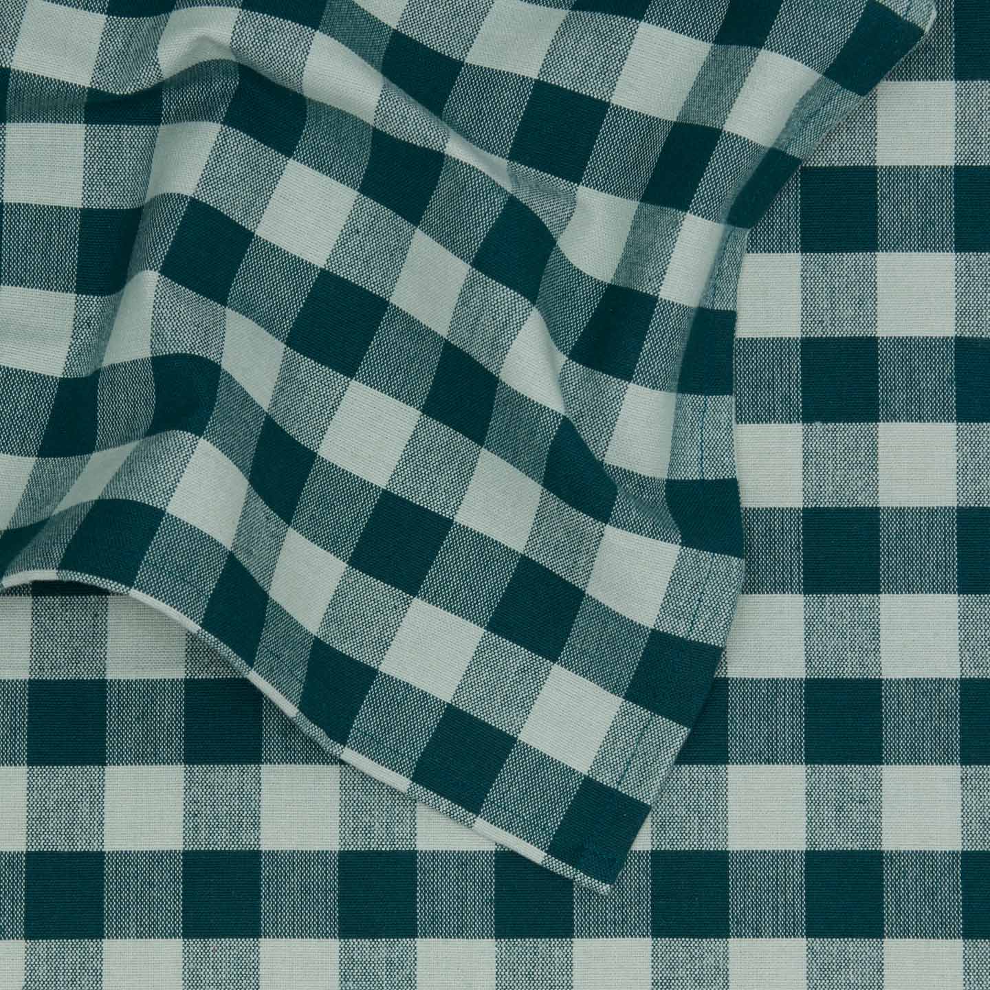 Close up view of Essential Gingham tablecloth in sky/peacock