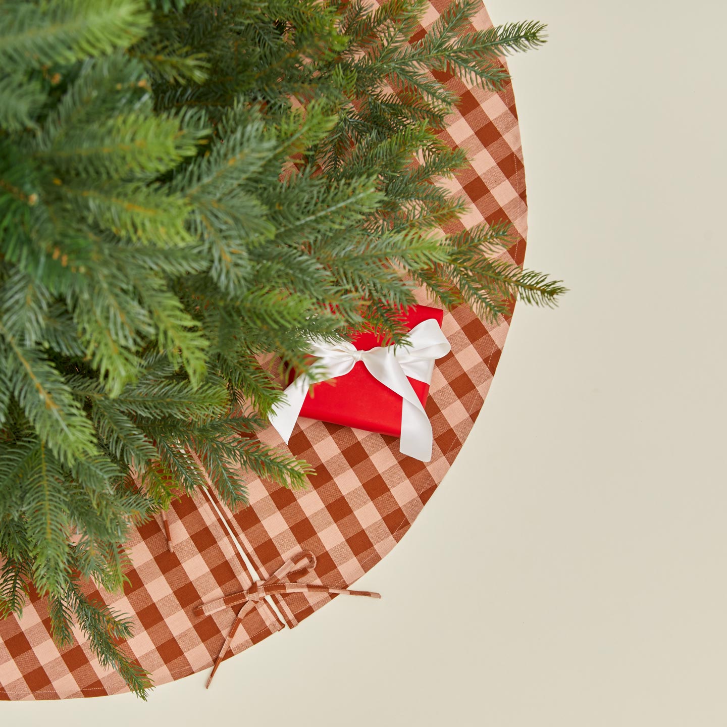 Overhead view of Essential GIngham Tree Skirt - Blush/Terracotta with tree