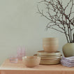 Tabletop with stacked Essential Dinnerware and Essential Glassware in Blush.