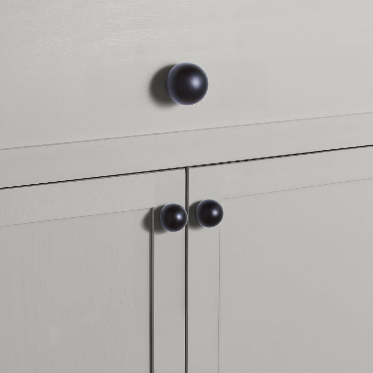Large and small black essential sphere knobs on drawers and cabinets