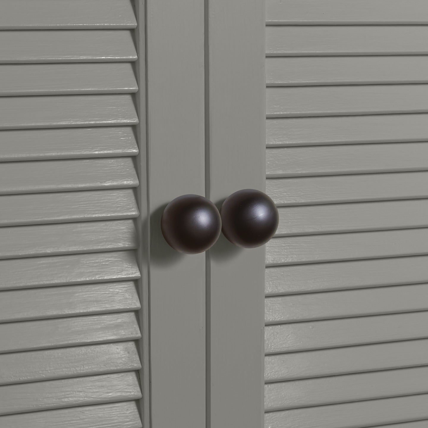 Large black essential sphere knobs on louvered doors