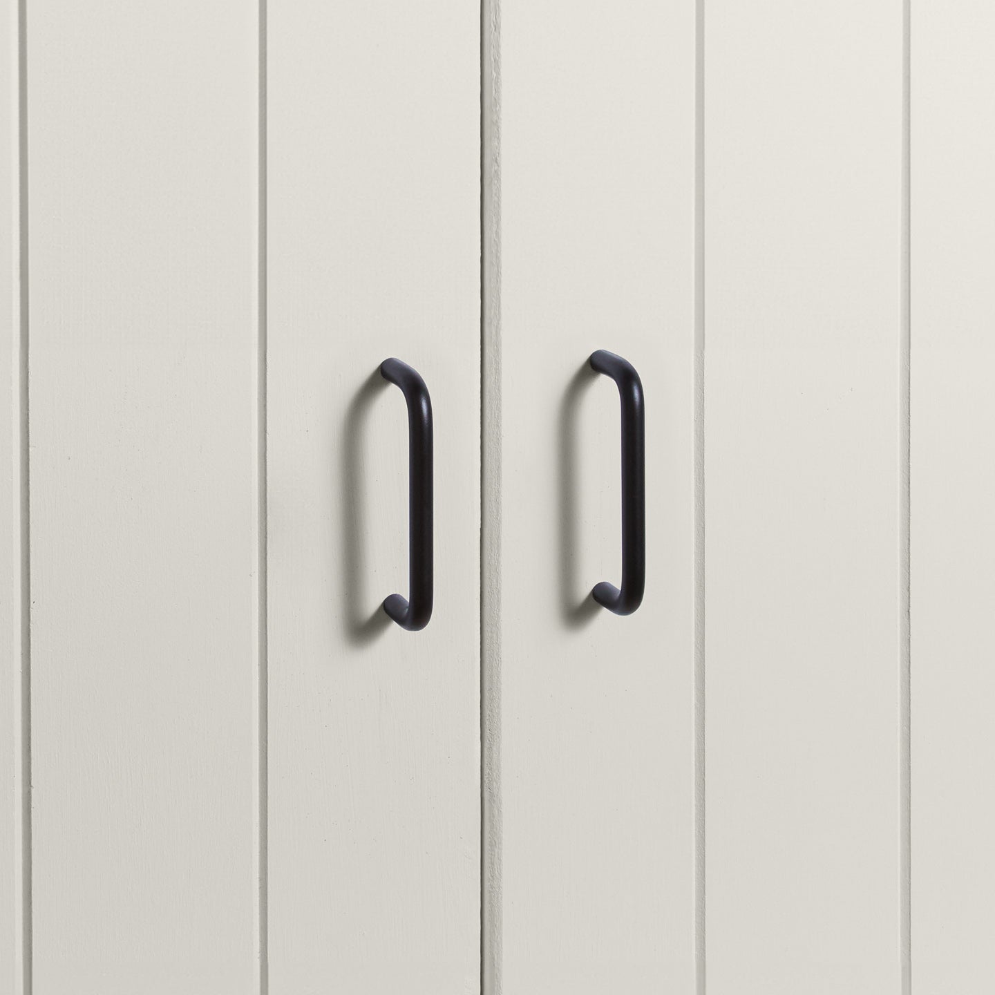Small black pulls on white doors