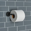 Essential toilet paper holder in Black with a roll of toilet paper on tiled wall.