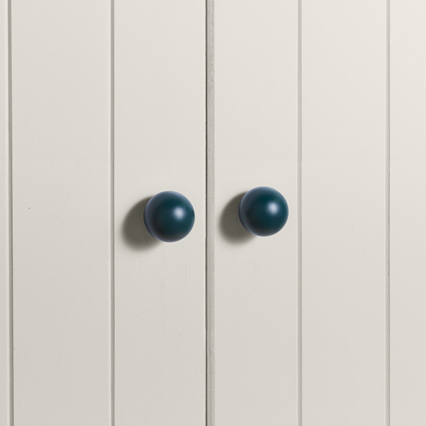 Large peacock essential sphere knobs on white doors