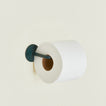 Toilet paper holder in Dark Peacock with a roll of toilet paper.