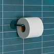 Essential toilet paper holder in Dark Peacock with a roll of toilet paper on tiled wall.