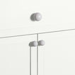 Large and small ivory essential sphere knobs on white drawers and cabinets