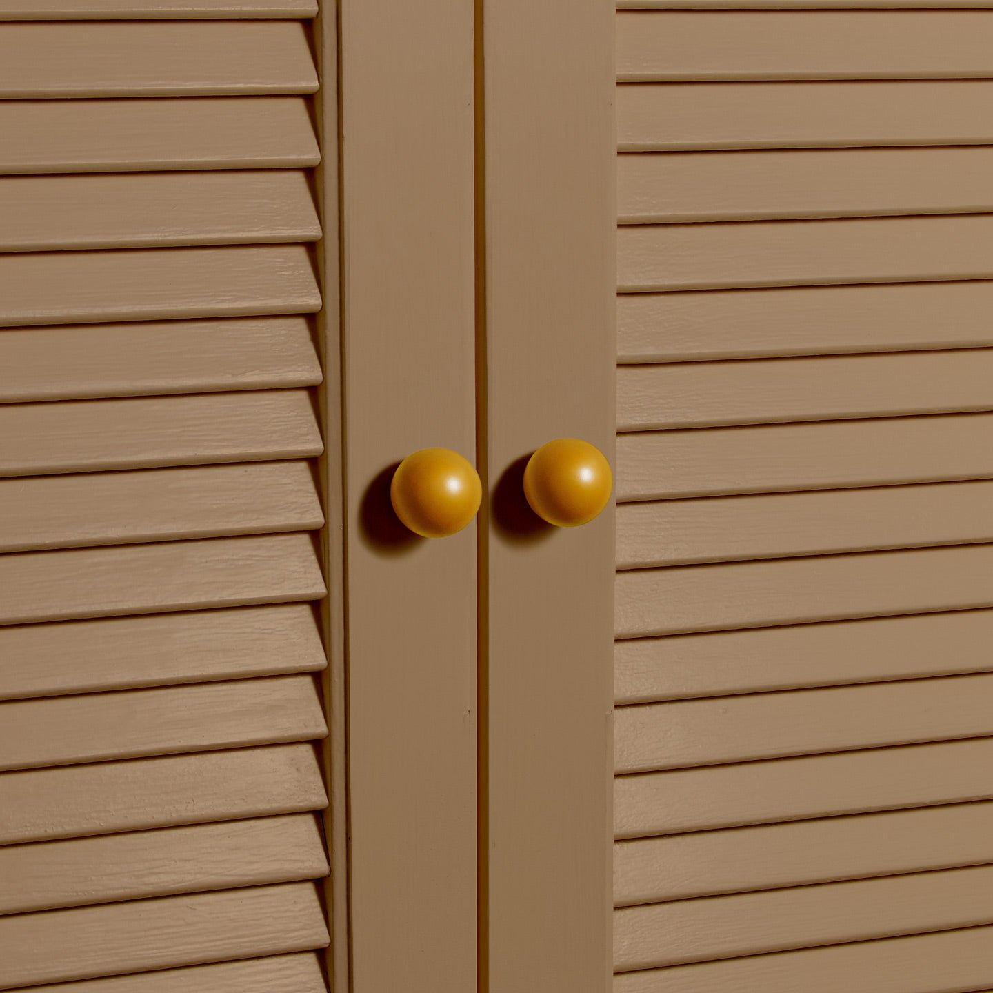 Small mustard essential sphere knobs on louvered doors