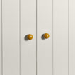 Small mustard essential sphere knobs on white doors