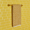 Essential towel bar in Mustard with Space Dye terry hand towel in Mustard on tiled wall.
