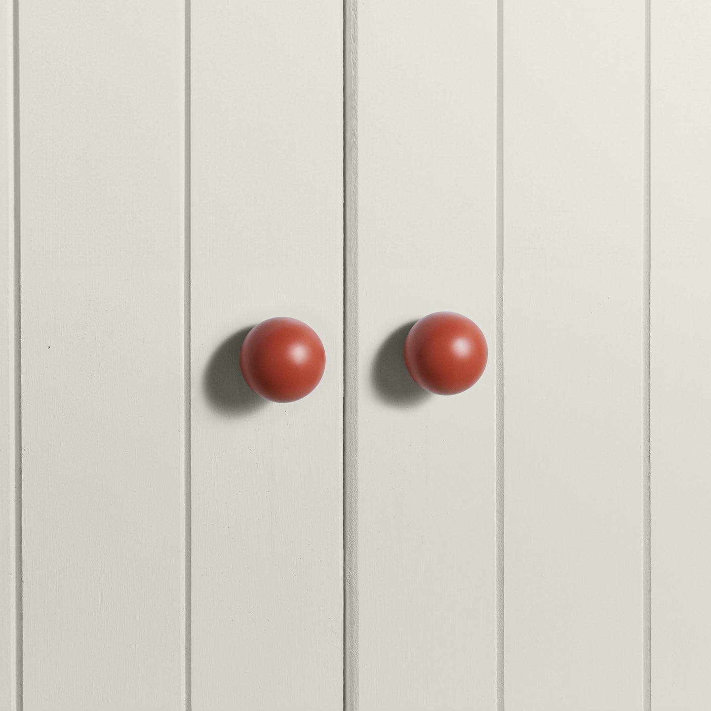 Large terracotta essential sphere knobs on white doors