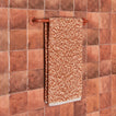 Essential towel bar in Terracotta with Space Dye terry hand towel in Terracotta on tiled wall.