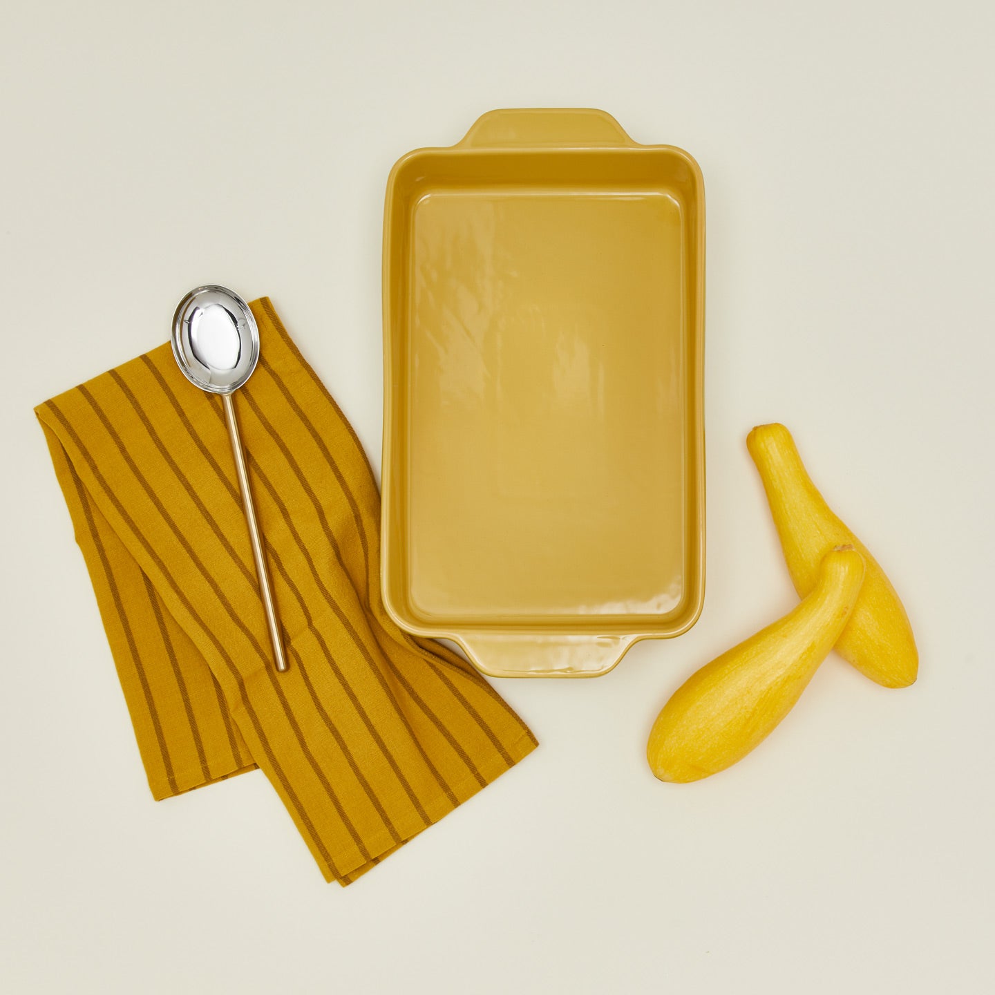 9" x 13" bakeware in mustard with, spoon, squash, and dish towel