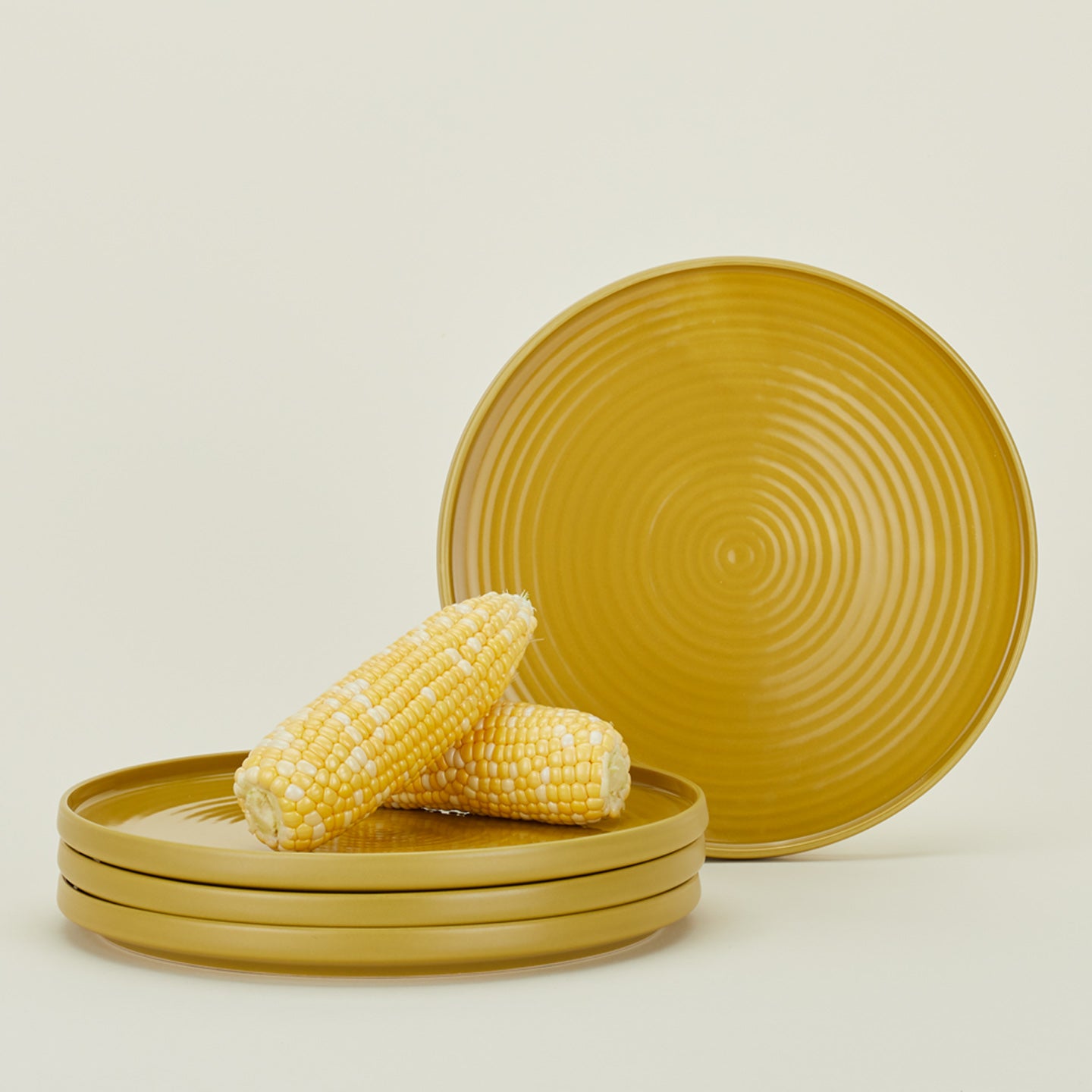 Four Essential Dinner Plates in Mustard, with corn.