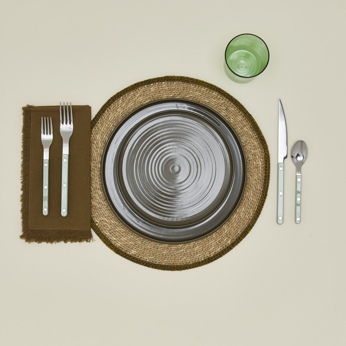 Essential Woven Placemat in olive with place setting.
