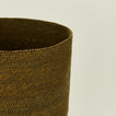 Close up view of essential woven wastebasket in olive