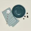 Essential pie dish in peacock with slotted spoon blackberries and dishtowel