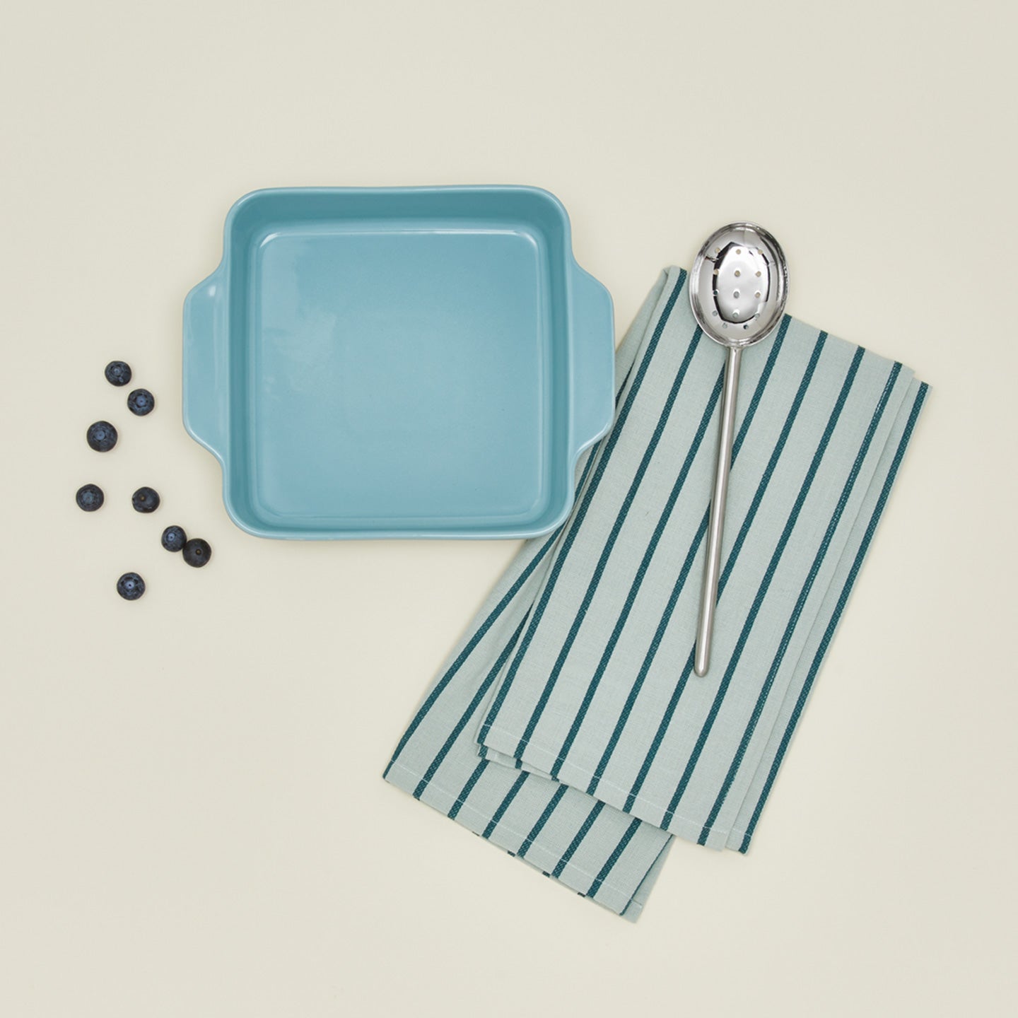 8" x 8" Essential bakeware in sky with blueberries, slotted spoon, and dishtowels