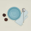 Essential pie dish in sky with plums, spoon and oven mit