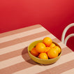 Essential Striped Tablecloth in Blush with Essential Mustard bowl with oranges and dark pink background.