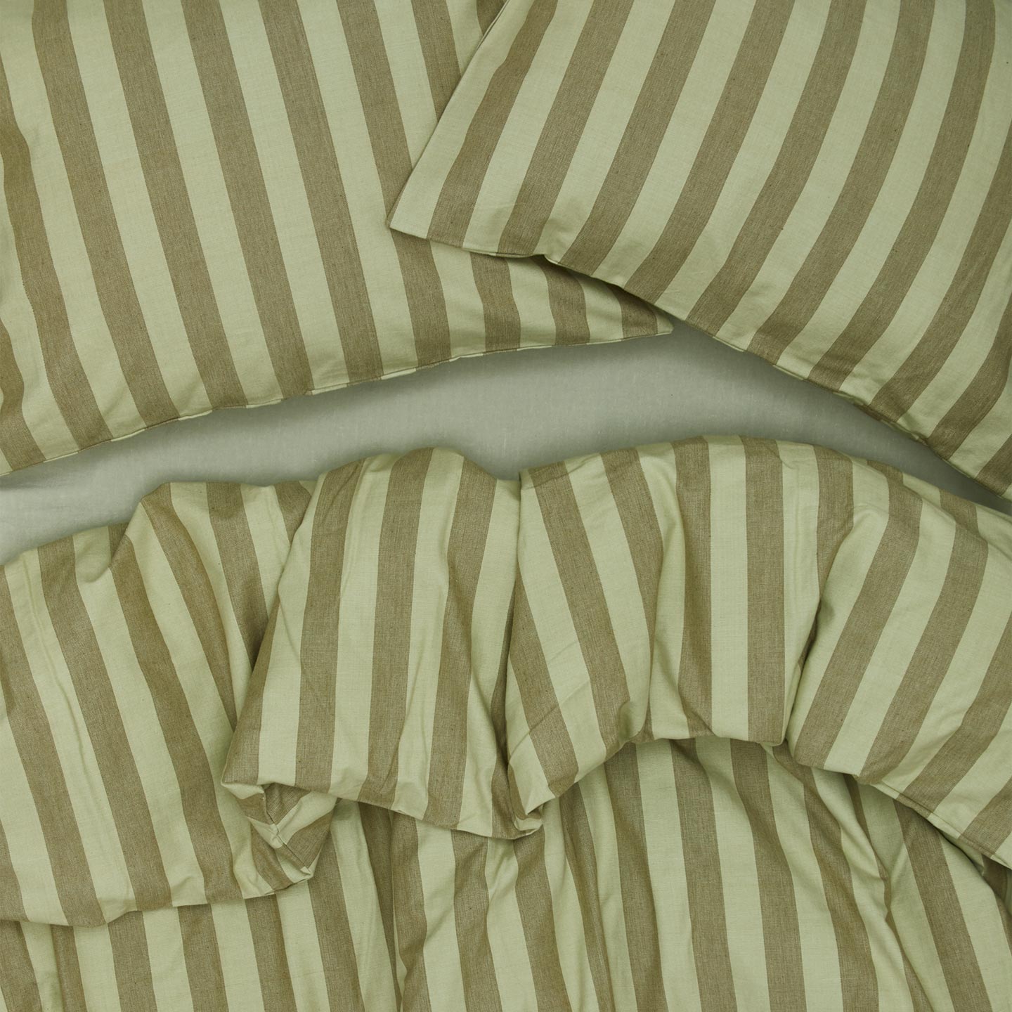Essential Stripe Pillowcases, Set of 2 - Sage/Olive on bed with matching duvet