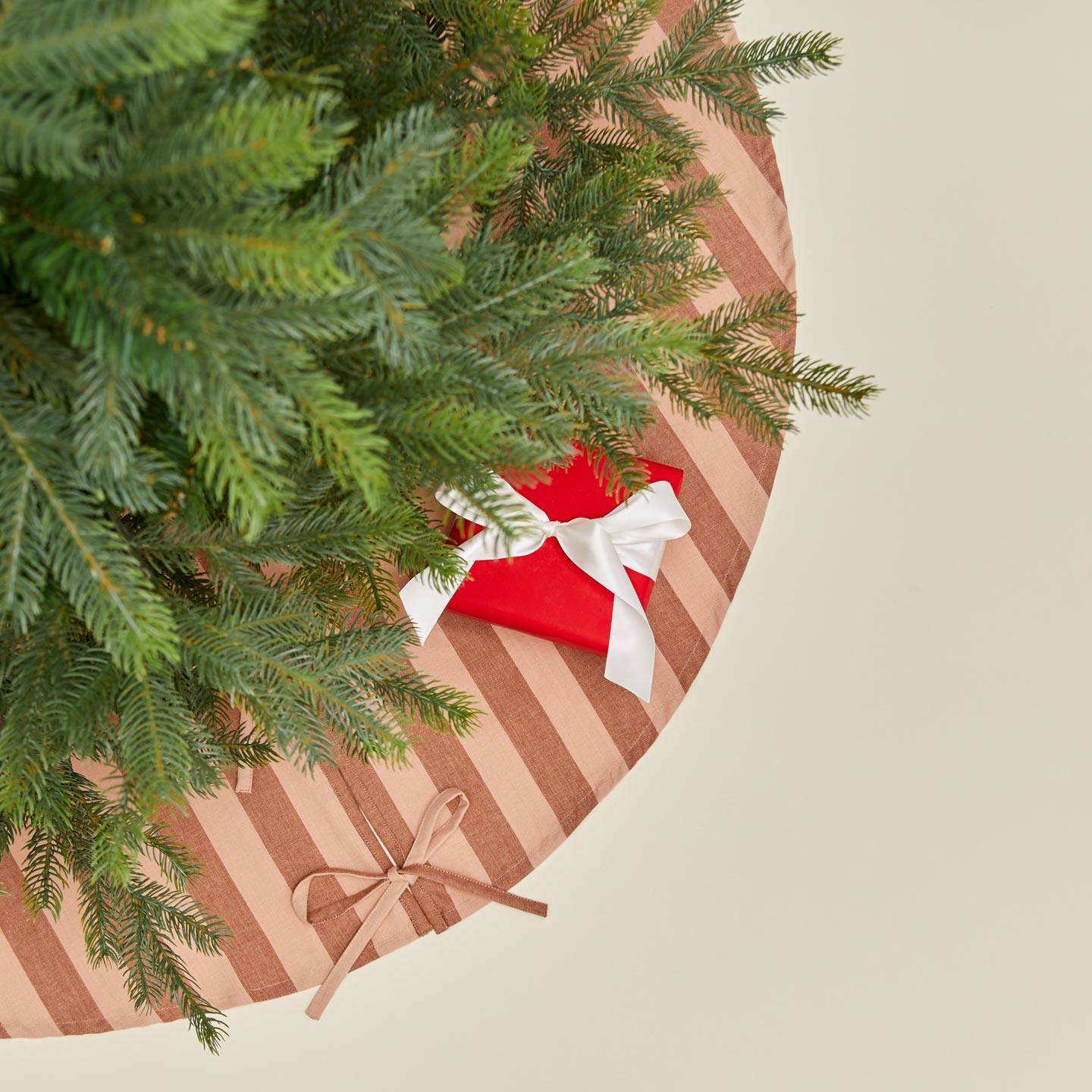 Overhead view of Essential Striped Tree Skirt - Blush/Terracotta with tree
