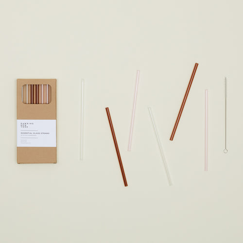 Kraft colored gift box of Essential Glass Straws in Warms, with straws scattered nearby.