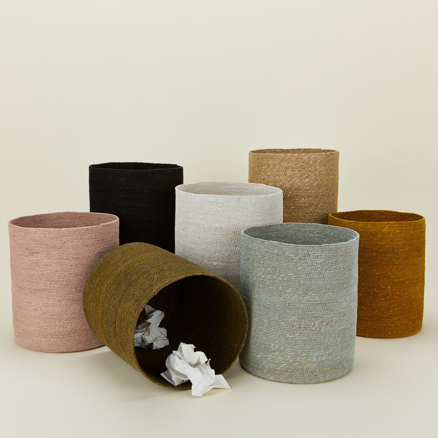Essential woven wastebasket family in various colors.
