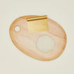 Brass dough scraper on a wood cutting board with dough.