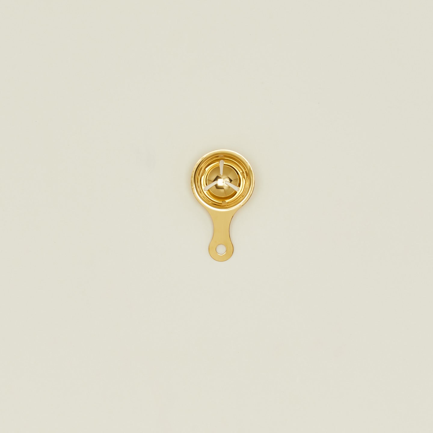 Brass egg separator on a beige background