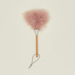 Pink feather duster with wooden handle on a beige background