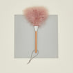 Pink feather duster with wooden handle on a gray background