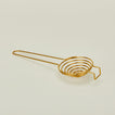 Brass swirl egg separator close up on ivory background.